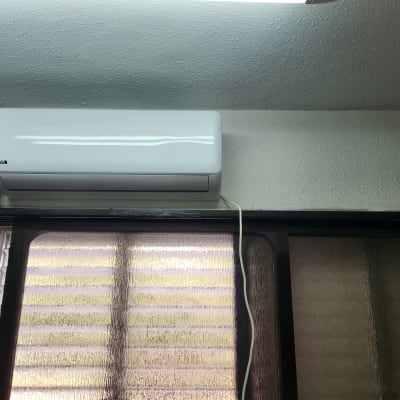 מזגן מותקן על קיר עם חוט חשמל מחובר