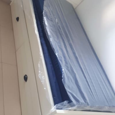 מזרן עטוף בניילון על מיטה לבנה