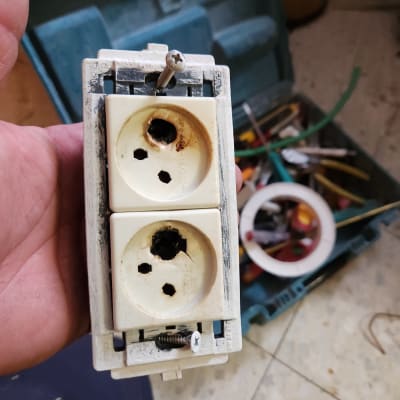 שקע חשמלי שרוף עם כלי עבודה ברקע