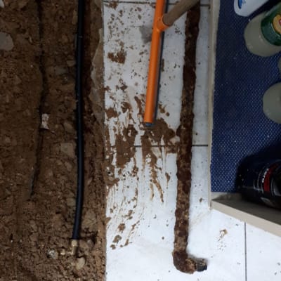 צינור שחור וכתום, אדמה על רצפה לבנה