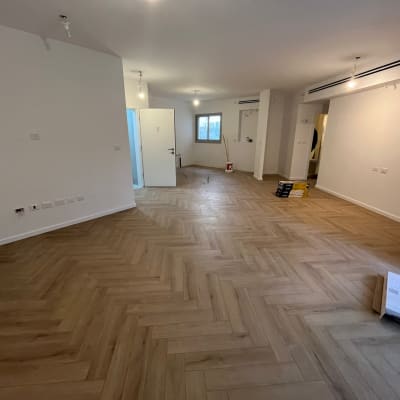 רצפת פרקט עץ בהתקנה בחדר ריק עם קופסאות