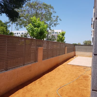 חול, צינור מים, גדר עץ, עצים ברקע