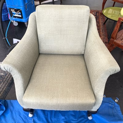 כיסא מרופד עם מכונת ניקוי כחולה ברקע