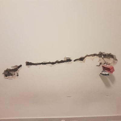 קיר עם חור ותיבת חשמל חשופה