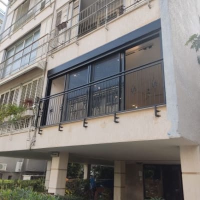 מרפסת עם מסגרות מתכת שחורות ודלתות זכוכית