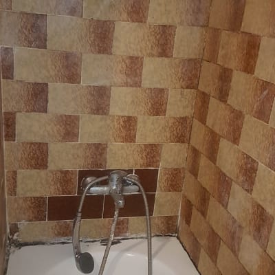 ברז אמבטיה עם צינור מקלחת על קיר אריחים