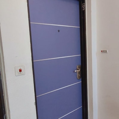 דלת סגולה עם ידית כסופה במסגרת שחורה