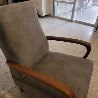 כורסה מרופדת עם ידיות עץ בחדר מגורים