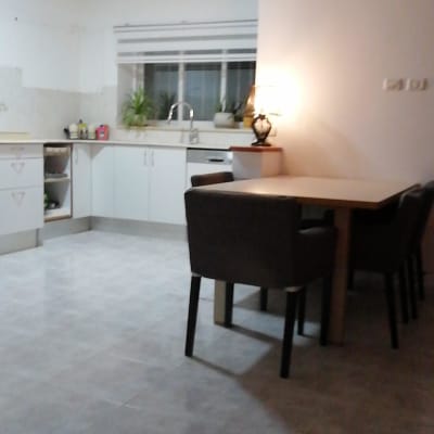 מטבח עם ארונות לבנים, כיור וצמחים על השיש