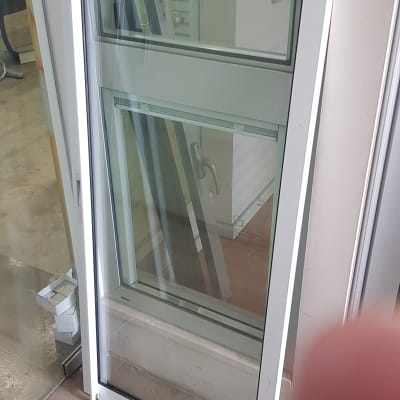 חלון זכוכית עם מסגרת לבנה עומד על הרצפה