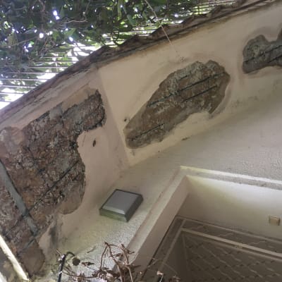 קיר עם טיח מתקלף וברזלים חשופים