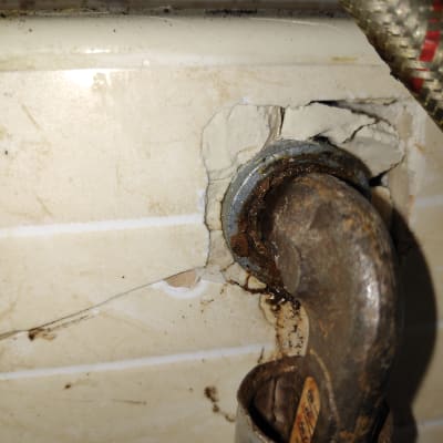 צינור חלוד עם חיבור לקיר, נזילה קלה