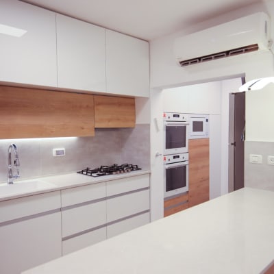 מטבח מודרני עם ארונות לבנים, כיור ותנור