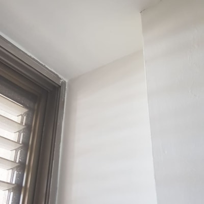 קיר צבוע בלבן ליד חלון עם תריסים