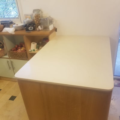 משטח שיש לבן במטבח עם ארונות עץ