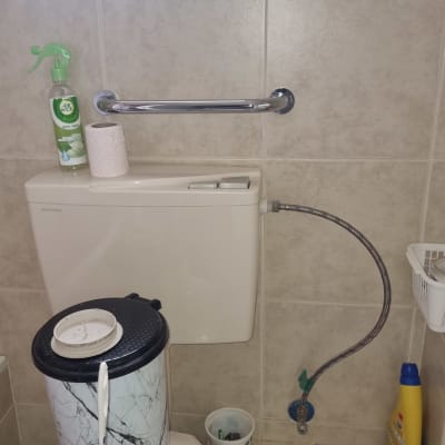 מיכל הדחה עם צינור מים ומחזיק נייר טואלט