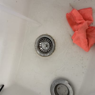 כיור עם ניקוז ומטלית כתומה