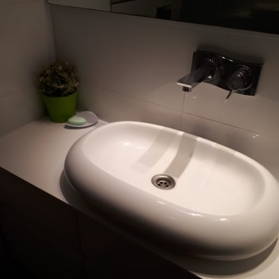 כיור לבן על משטח שיש בחדר אמבטיה