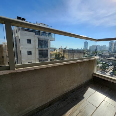 מעקה זכוכית במרפסת עם נוף עירוני