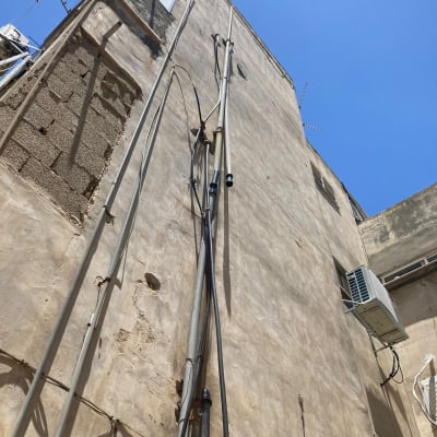 כבלים וצינורות על קיר חיצוני של בניין