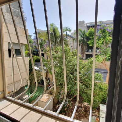 סורגים מתכתיים על חלון פתוח עם נוף חיצוני