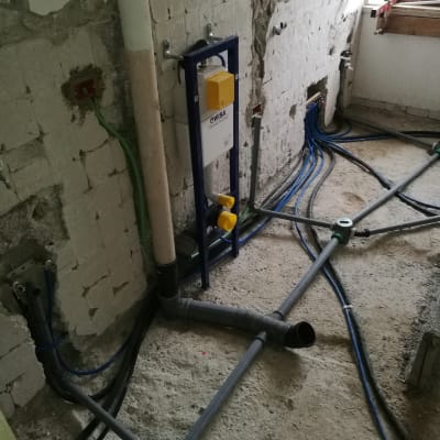 צנרת מים וביוב מותקנת בקיר חשוף במהלך שיפוץ