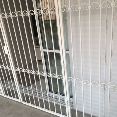 סורגים לבנים עם עיטורים על חלון זכוכית