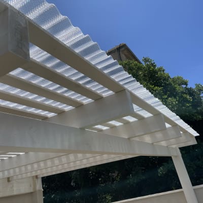 פרגולה מעץ עם כיסוי פלסטיק שקוף בגינה