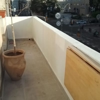 מעקה מרפסת צבוע בלבן עם לוח עץ