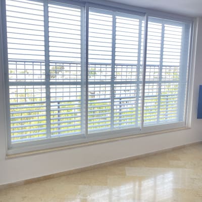 תריסי אלומיניום לבנים על חלון גדול