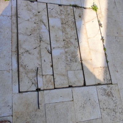 רצפה מלוכלכת עם עשבים שוטים בין האריחים