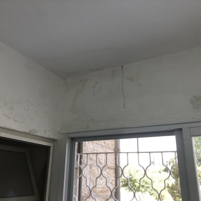 קיר עם קילופי צבע וסדקים לפני צביעה