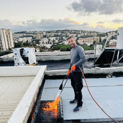 אדם עם מבער אוטם גג עם יריעות ביטומניות