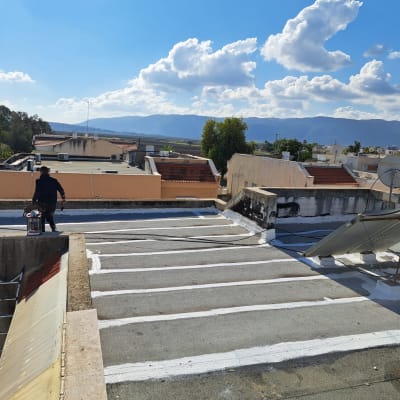 אדם על גג עם ציוד לאיטום וסימני איטום לבנים