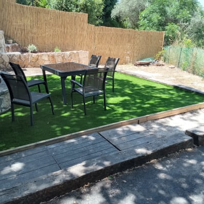 דשא סינתטי עם שולחן וכיסאות בגינה
