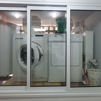 מכונת כביסה ומייבש מאחורי חלון זכוכית