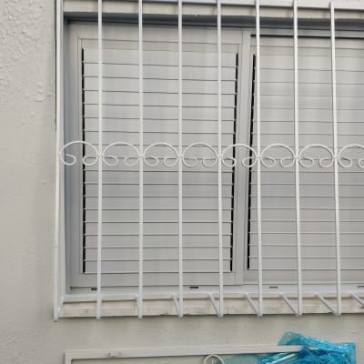 חלון עם תריסים וסורגים לבנים