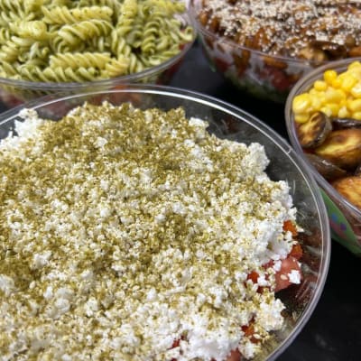 מגוון סלטים בקערות שקופות עם תוספות שונות