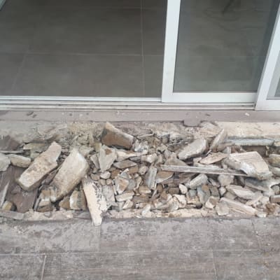 הריסות בטון ואבנים ליד דלת זכוכית