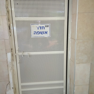 דלת מתכת מחוררת עם שלט חדר אשפה