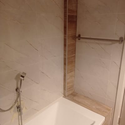 אמבטיה חדשה עם אריחים מודרניים וברז מותקן