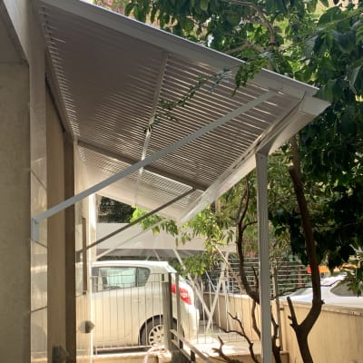 סוכך מתכת לבן מחובר לקיר עם תמיכה