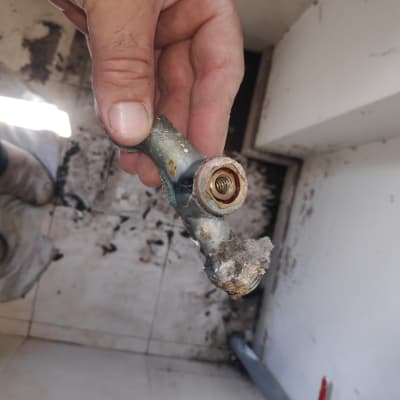 יד מחזיקה צינור מתכת חלוד עם לכלוך