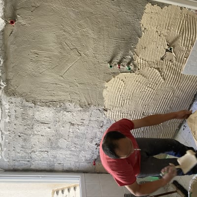 אדם מורח טיח על קיר במהלך שיפוץ