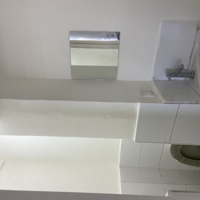 כיור לבן עם ברז, מראה קטנה על הקיר