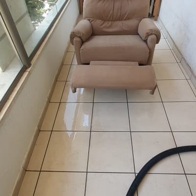 כיסא עור חום על מרפסת עם רצפה רטובה