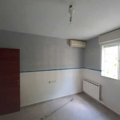 חדר עם קיר צבוע חלקית בצבע אפור