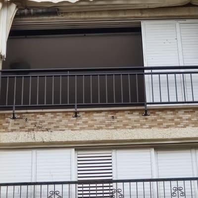 מרפסת עם מעקה מתכת ותריסים לבנים