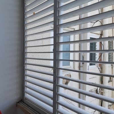 תריסים לבנים אופקיים על חלון