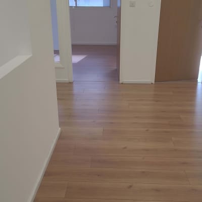 רצפת עץ נקייה במסדרון עם דלתות פתוחות